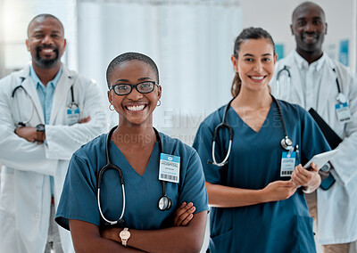 Group of happy diverse doctors standing with their arms crossed while working at a hospital. Content expert medical professionals smiling at work together at a clinic