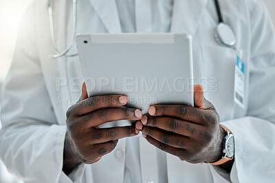 Buy stock photo Doctor holding and using a digital tablet while working at a hospital alone. Expert medical professional doing research on a digital tablet while at work at a clinic
