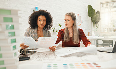 Buy stock photo Two businesspeople collaborate on a project together. Team of designers reading documents together. Mature businesswoman working with her staff member. Boss working on a architectural project
