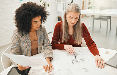 Buy stock photo Mature businesswoman working with a colleague. Coworkers working on a building project. Team of architects brainstorm and collaborate. Boss working on a blueprint with her staff member.