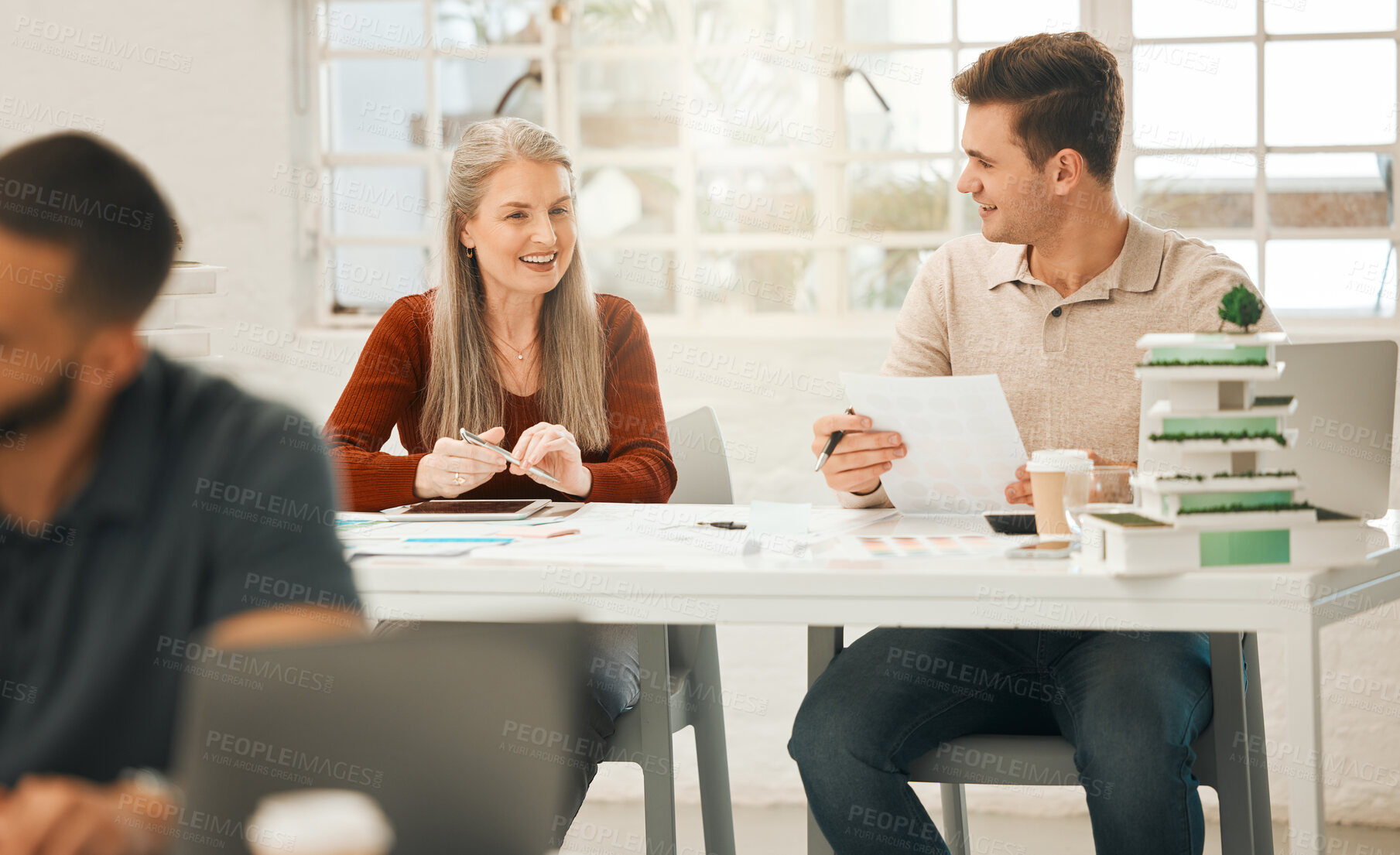 Buy stock photo Mature businesswoman talking to a coworker. Two colleagues planning together. Businesspeople collaborate in an office. Professional designers talking about report. Happy colleagues working together