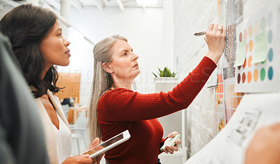 Buy stock photo Mature businesswoman brainstorming with staff. Leading businesswoman writing down her ideas. Serious businesswomen collaborate. Engineers working in architecture agency together.