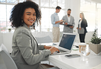 Buy stock photo Portrait of a young mixed race businesswoman working on a laptop at work. Happy hispanic female businessperson with a curly afro typing en email on a laptop in an office