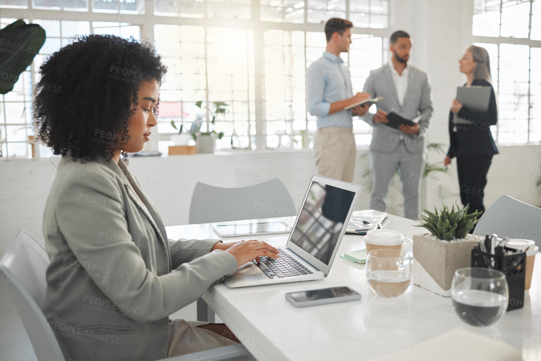 Buy stock photo Portrait of a focused mixed race businesswoman working on a laptop at work. Hispanic female businessperson with a curly afro typing en email on a laptop in an office