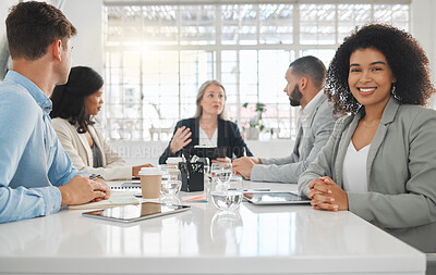 Buy stock photo Portrait of a young happy mixed race businesswoman with a curly afro sitting in a meeting at work. Group of businesspeople having a meeting together at a table. Business professionals talking and planning in an office