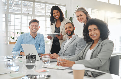 Buy stock photo Diverse group of businesspeople having a meeting together at a table at work. Business professionals talking and planning while using technology in an office. Colleagues working together