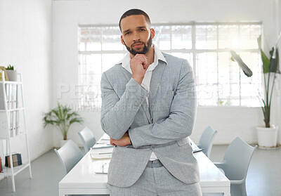 Buy stock photo Young focused mixed race businessman standing in an office alone. One serious confident hispanic male boss at work