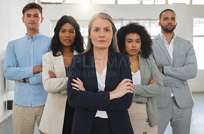 Buy stock photo Group of diverse and powerful businesspeople standing together with their arms folded in an office. Confident and mature manager leading her team of professionals in the workplace. Global business
