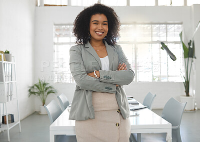 Buy stock photo Young happy mixed race businesswoman standing with her arms crossed while in an office alone. One confident hispanic female boss with a curly afro smiling and standing at work