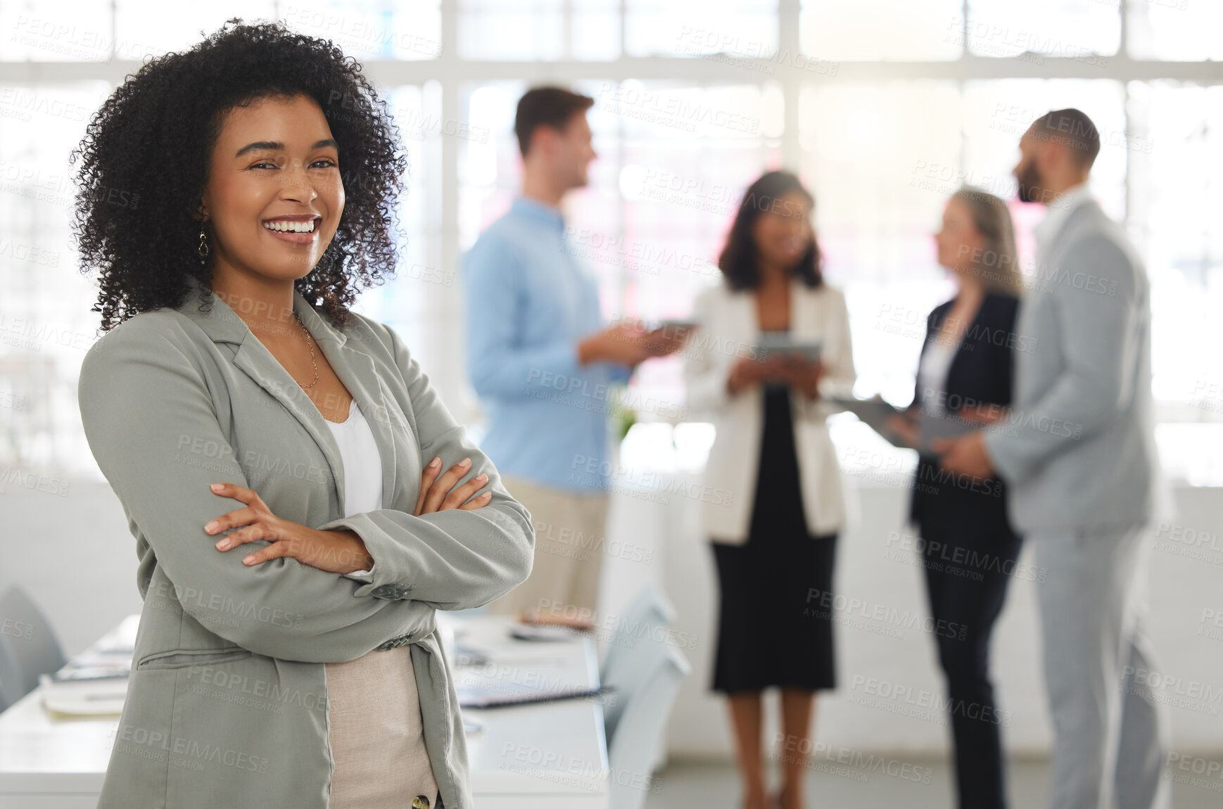 Buy stock photo Young happy mixed race businesswoman standing with her arms crossed while in an office alone. One confident hispanic female boss with a curly afro standing in a meeting with coworkers