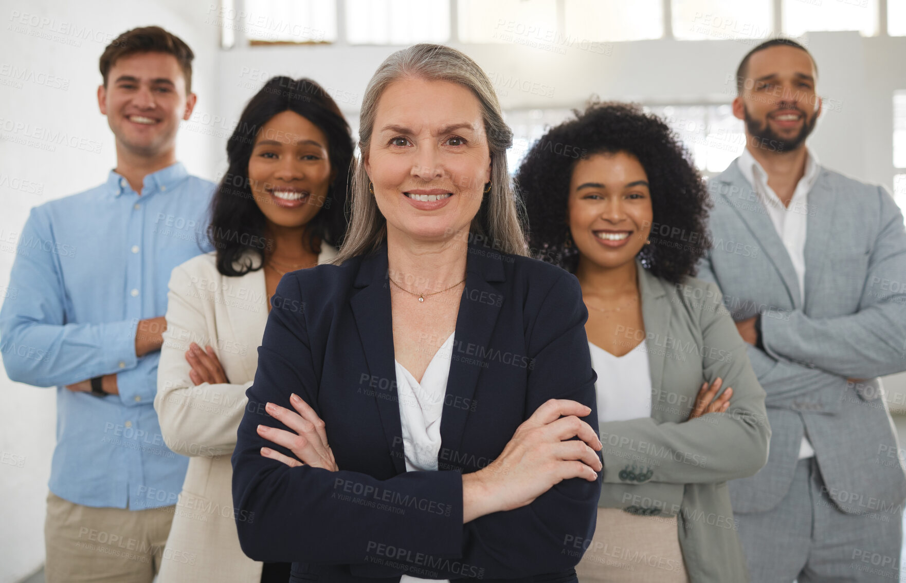 Buy stock photo Group of diverse and powerful businesspeople standing together with their arms crossed in an office. Confident and mature manager leading her team of professionals in the workplace