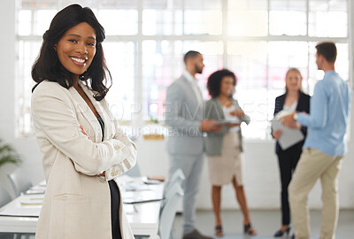Buy stock photo Young happy african american businesswoman standing with her arms crossed while in an office with colleagues. Black female boss In a meeting with coworkers