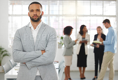 Buy stock photo Young mixed race businessman standing with arms crossed while in an office with colleagues. Serious hispanic male boss In a meeting with coworkers
