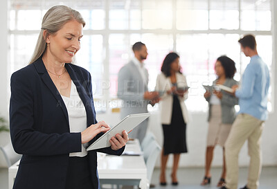 Buy stock photo Mature happy caucasian businesswoman working on a digital tablet in an office. One confident female boss smiling and holding a digital tablet while in a meeting at work