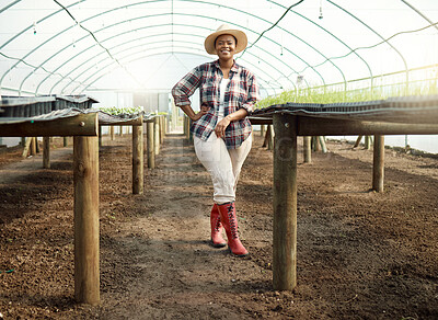 Buy stock photo Full body of young farmer in a garden. Portrait of a proud farmer in her greenhouse. Happy african american farmer. Young farmer standing in her garden. Farm employee standing in a nursery