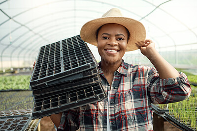 Buy stock photo Happy farmer carrying empty trays. African american farmer working in a greenhouse. Young farmer cultivating seedlings. Portrait of happy farmer in her garden. Portrait of confident farmer