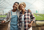 Portrait of two happy farmers. Young farmers hugging one another. Cheerful colleagues standing in their greenhouse. Two farm workers in their garden. Coworkers in agriculture.