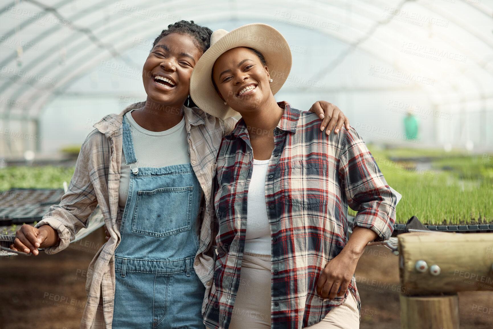 Buy stock photo Portrait of two happy farmers. Young farmers hugging one another. Cheerful colleagues standing in their greenhouse. Two farm workers in their garden. Coworkers in agriculture.