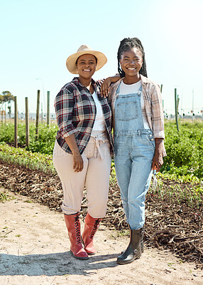 Two farmers embracing. Portrait of two happy farmers. Farmers standing in their garden. Smiling farmers on their farm. Two women working on a farm together.Confident young farmers standing together