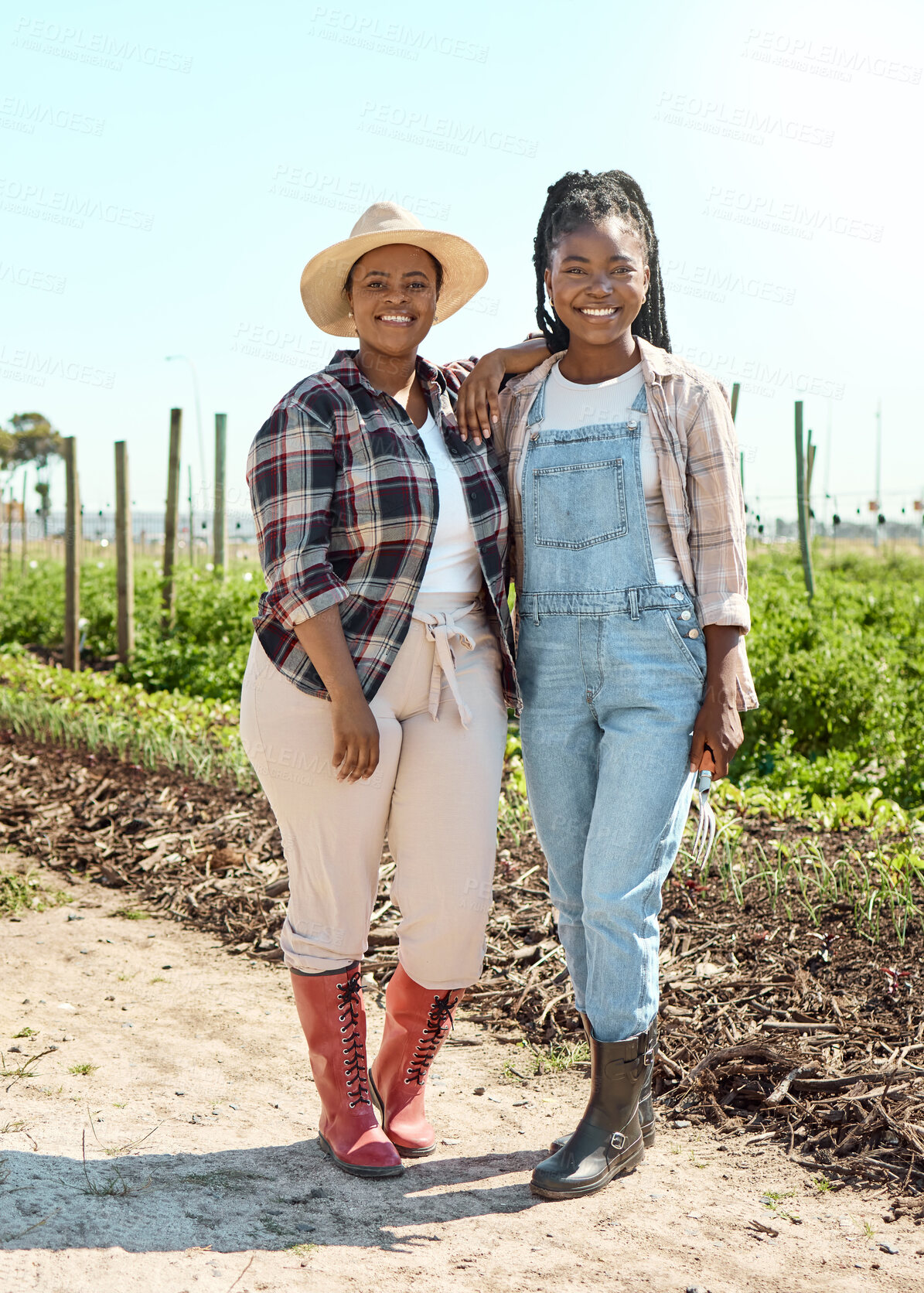 Buy stock photo Two farmers embracing. Portrait of two happy farmers. Farmers standing in their garden. Smiling farmers on their farm. Two women working on a farm together.Confident young farmers standing together