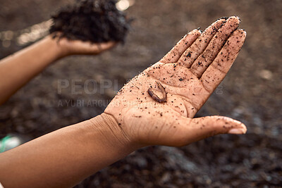 Buy stock photo Hand of a farmer holding a worm. Closeup of a farmer holding dirt. Hand of farmer covered in soil. Farmer holding dirt in a plant nursery. Farmer on a sustainable farm holding a worm.