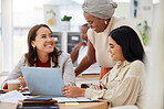 Diverse group of smiling business women using a laptop for a brainstorm meeting in an office. Happy confident professional team of colleagues using technology to talk and planning a marketing strategy