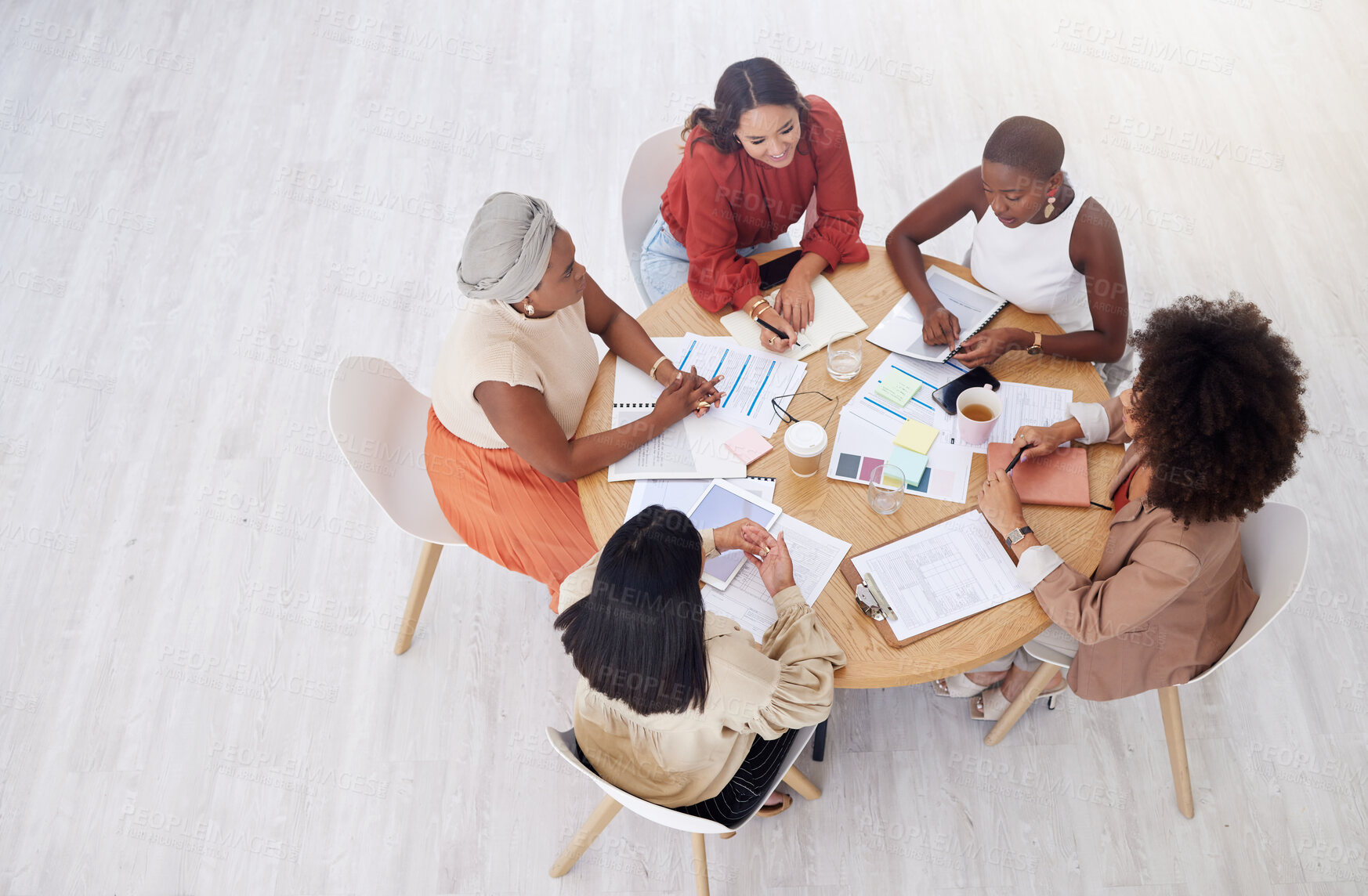 Buy stock photo Collaboration, planning and overhead with a business women team reading documents during an office meeting. Teamwork, strategy and diversity with a female employee group working together from above