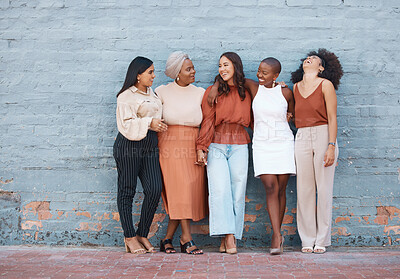 Buy stock photo Laughing, diversity and a team of business black women outdoor on a blue brick wall for conversation. Talking, joking or bonding with a female employee and colleague group taking a break outside