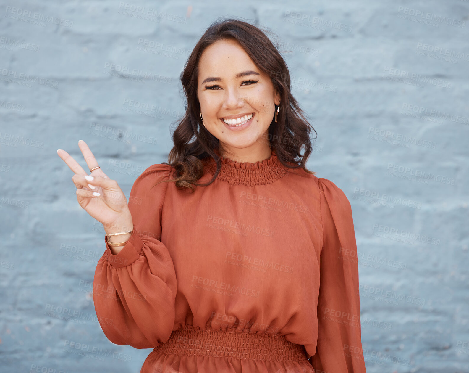 Buy stock photo Happy woman, portrait smile and beauty with peace sign against a gray wall background. Excited and friendly female face smiling showing peaceful hand emoji, symbol or gesture with positive attitude