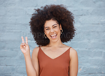 Buy stock photo Happy woman, portrait smile and afro with peace sign against a gray wall background. Excited or friendly female face smiling showing peaceful hand emoji or gesture with fun positive attitude