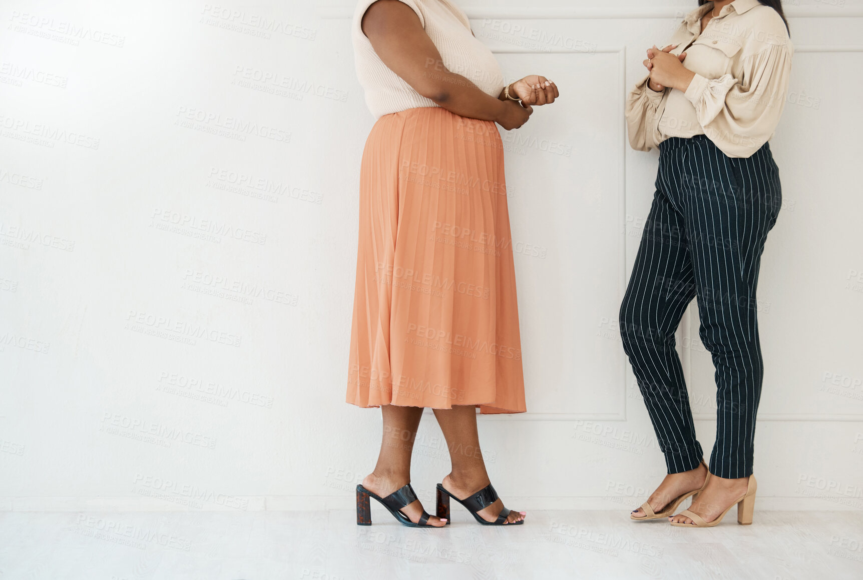 Buy stock photo Fashion, formal and business women by a wall in the office in conversation for teamwork. Discussion, planning and legs of professional corporate female employees with luxury outfits in the workplace.