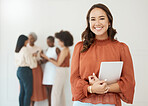 Portrait of a young happy mixed race businesswoman holding a digital tablet in an office at work. Cheerful hispanic businessperson smiling while holding a digital tablet