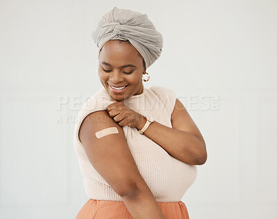 Buy stock photo Covid, smile and black woman with plaster on arm in studio for injection on medical insurance. Happy African female on a white background with vaccine, safety compliance and medicine mockup space