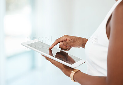 Unrecognizable person holding and using a digital tablet at home. Unrecognizable woman using social media on a digital tablet alone at work