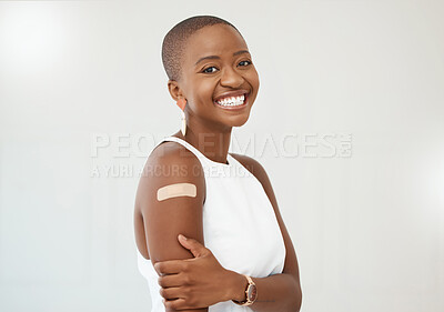Buy stock photo Black woman, portrait and covid plaster on arm in studio for injection with medical insurance. Portrait of African female happy on a white background with healthcare vaccine, safety and mockup space
