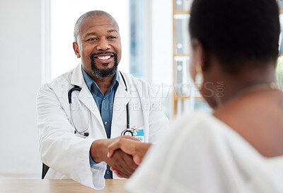 Doctor and patient handshake in the hospital. African american doctor greeting a patient for a checkup. Medical gp talking to a patient in a consult. Patient in treatment with a doctor