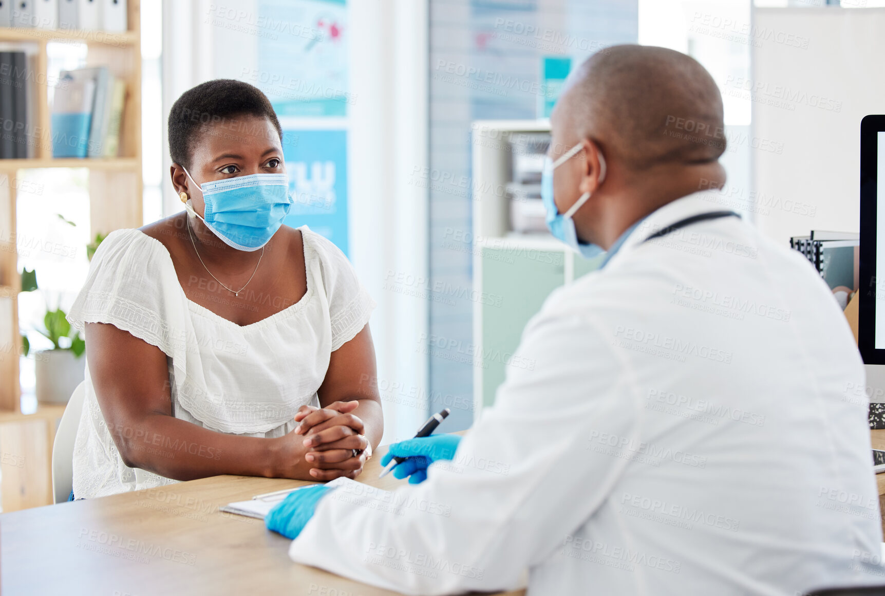 Buy stock photo Doctor, patient and consulting with face mask for covid checkup, appointment or diagnosis at hospital. Black man, medical professional talking to woman in consultation or healthcare visit at clinic