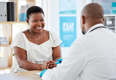African american woman smiling in checkup with doctor. Patient talking to her doctor in the hospital. caring doctor in a consult with his patient. Confident patient looking at her gp