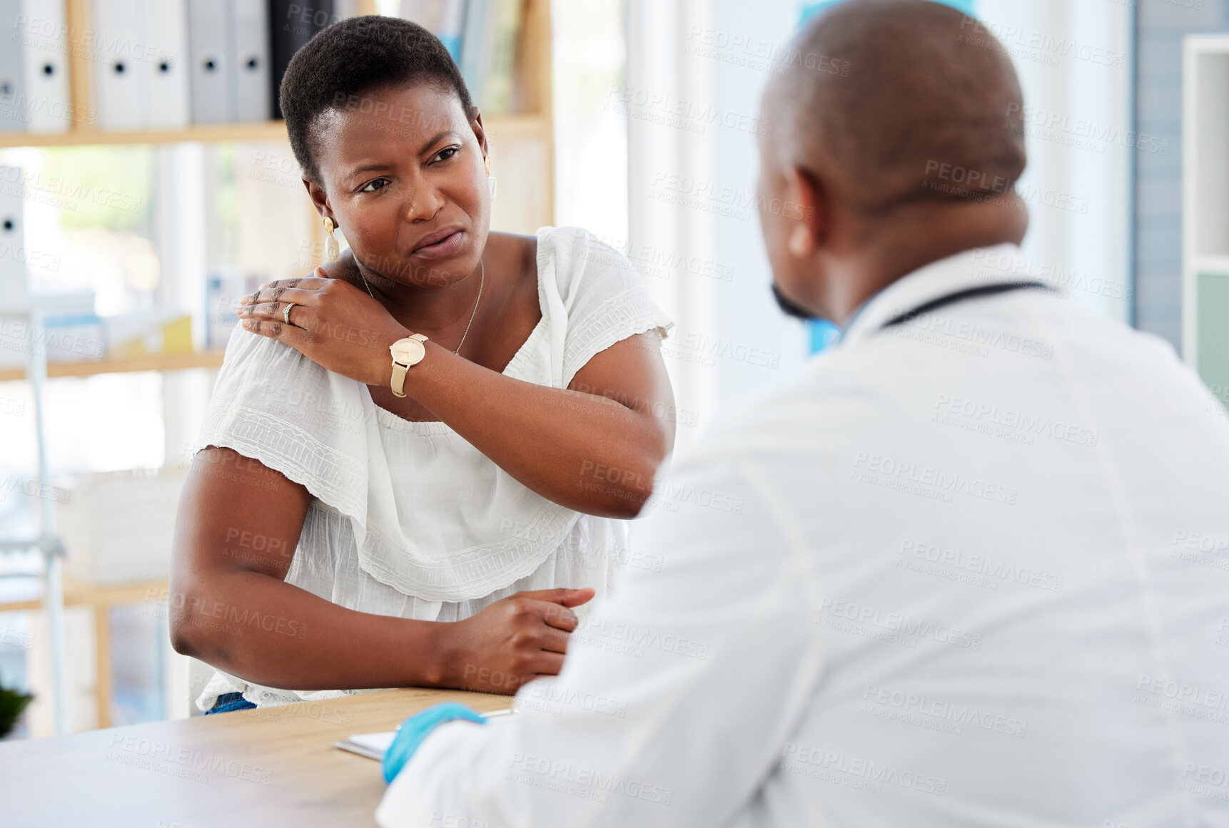 Buy stock photo Healthcare, consultation and woman with shoulder pain at the doctor in the hospital for treatment. Sick, conversation and female patient with back injury getting checkup with medical worker in clinic