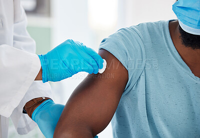 Closeup of doctor cleaning the arm of a patient. Doctor using cotton ball to clean a patients arm before injection. Patient about to get injected with covid vaccine. Patient in a checkup for corona