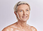 Beautiful mature caucasian woman posing topless and isolated against a pink background in a studio. Happy senior woman with glowing skin. Good skincare and a healthy routine is self care for your skin