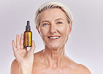 Portrait of a beautiful older woman posing against a purple background while holding an anti ageing serum. Mature woman treating wrinkles with a product and promoting essential oil