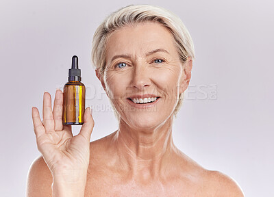Buy stock photo Skincare, beauty or makeup product in the hand of a senior woman holding face serum or cosmetic oil in studio on a purple background. Portrait of a female marketing, advertising or endorsing wellness