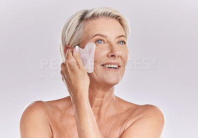 Buy stock photo Woman doing skincare for wellness, beauty product for facial health and cosmetic on face for healthy skin on mockup studio background. Person with smile doing gua sha massage for body with mock up