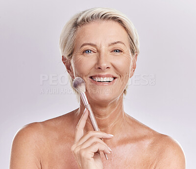Buy stock photo Beauty, skincare and makeup with a senior woman applying cosmetics to her face in studio against a purple background. Head portrait of a female with blusher looking beautiful, happy and healthy