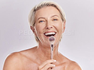 Buy stock photo Beauty, makeup skincare with a senior model holding a blusher brush in studio against a gray background. Portrait of an elderly woman with a smile posing for wellness, healthcare and cosmetics 