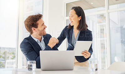Two happy young diverse colleagues working together on a digital tablet in an office. Confident asian businesswoman and smiling caucasian businessman discussing corporate plans and ideas on device. Secretary assisting boss at work