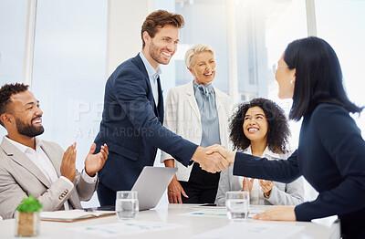 Smiling young businessman shaking hands with a businesswoman during a meeting in an office boardroom. Diverse businesspeople cheering and clapping hands while feeling inspired after a successful promotion, corporate deal and merger