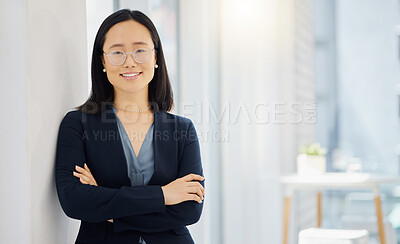 Portrait of one confident young asian businesswoman wearing glasses and standing with her arms crossed in an office. Ambitious entrepreneur and determined leader ready for success in her startup