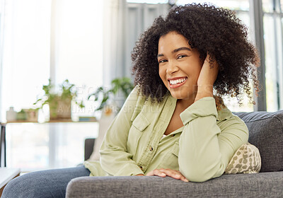 Buy stock photo Young happy mixed race woman sitting on the couch alone at home. One content hispanic female sitting at home. Woman with a curly afro smiling while sitting in the lounge at home